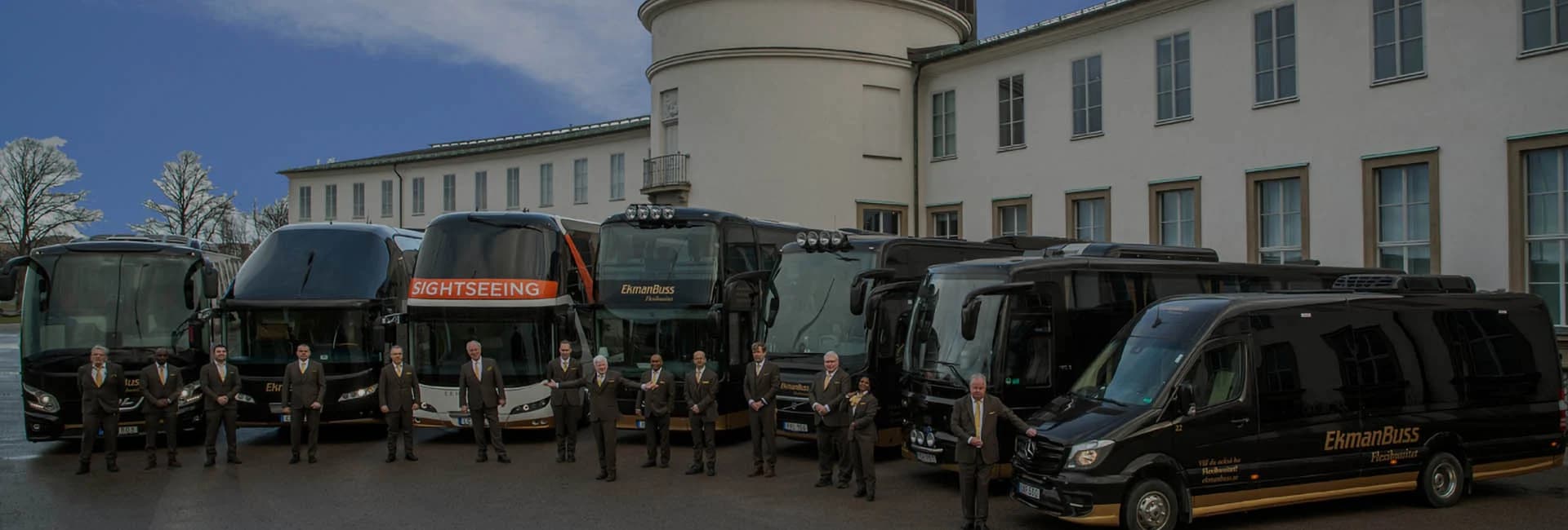 Modern vit turistbuss på väg genom en grön miljö utanför Stockholm.